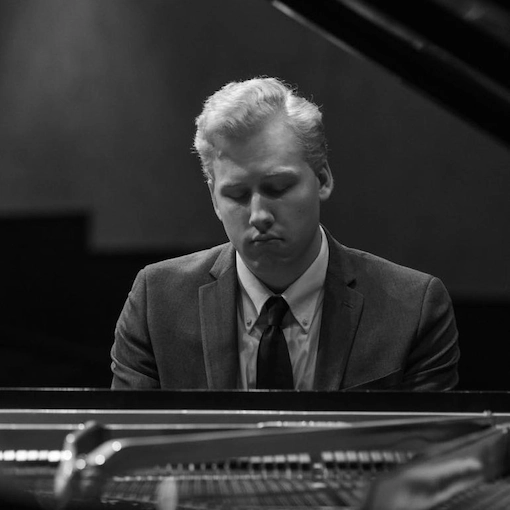Front-facing photo of Isaac Cox, sitting at piano.